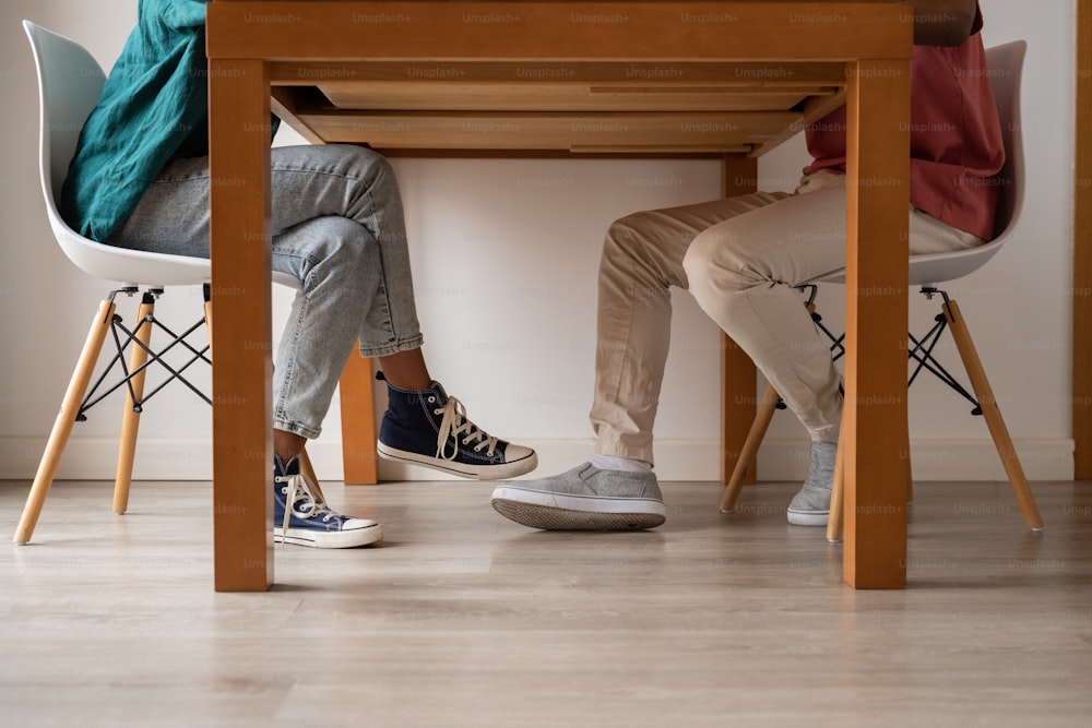 two people sitting at a table with a laptop