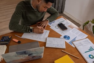a man sitting at a table with papers and a calculator