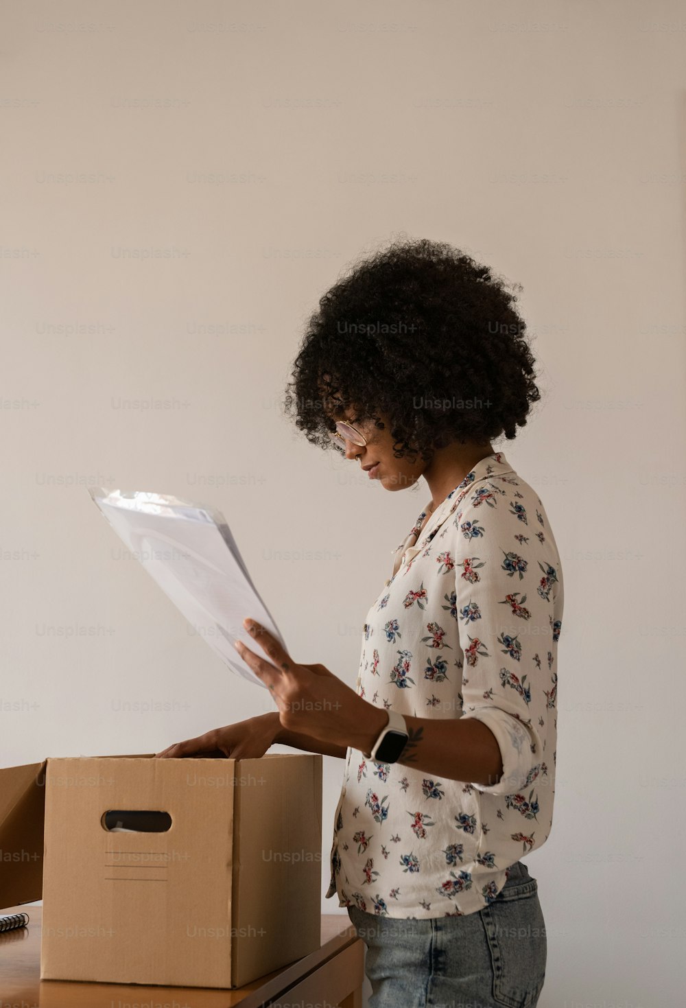 uma mulher em frente a uma caixa segurando um pedaço de papel