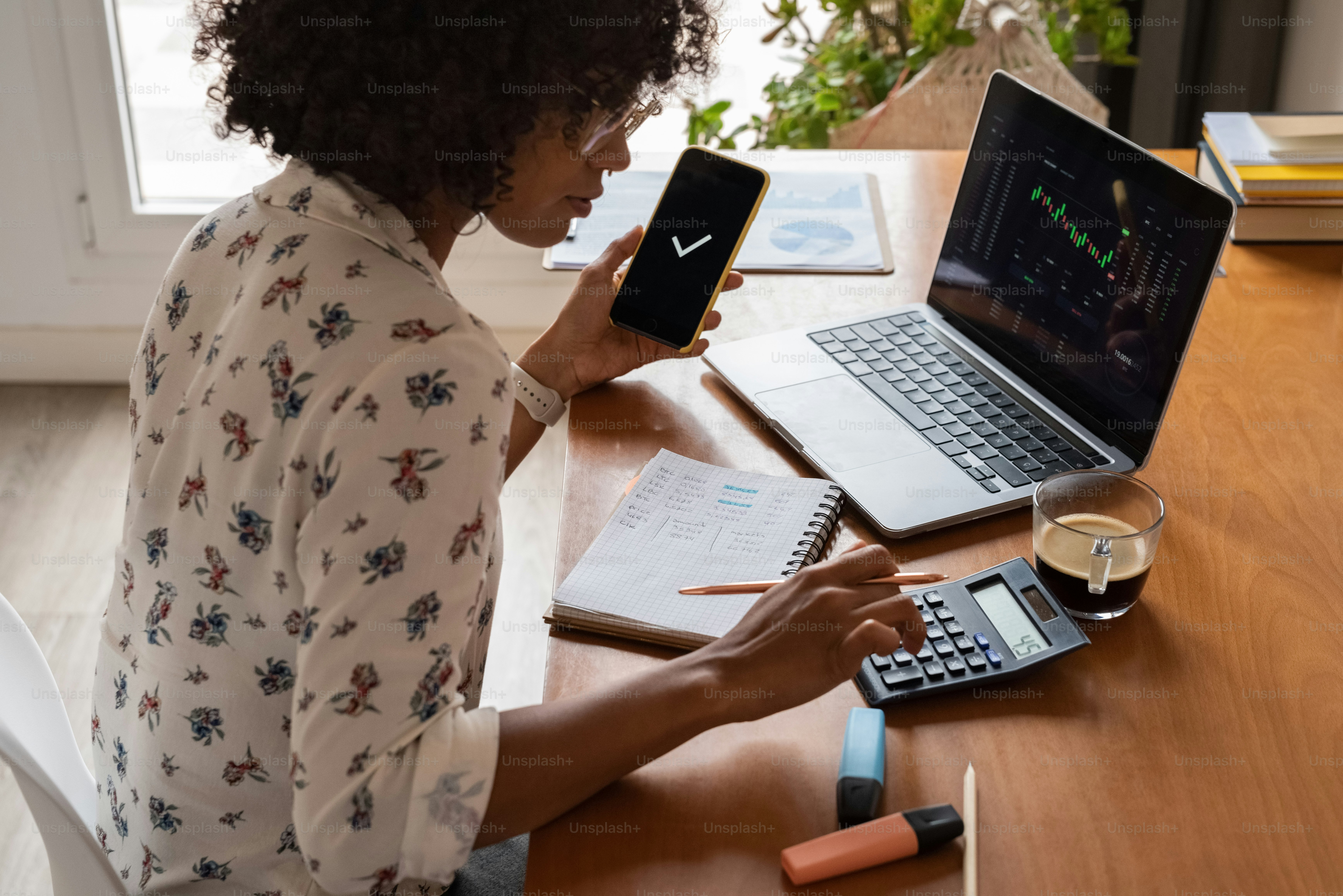 a woman sitting at a table with a laptop and calculator