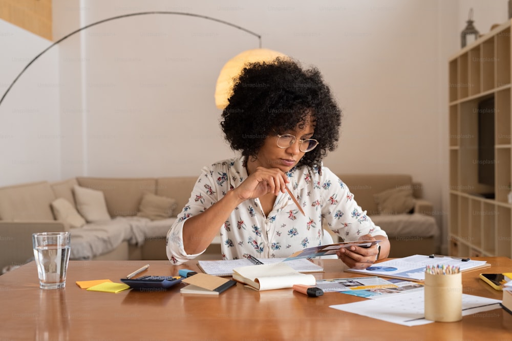 a woman sitting at a table looking at a cell phone