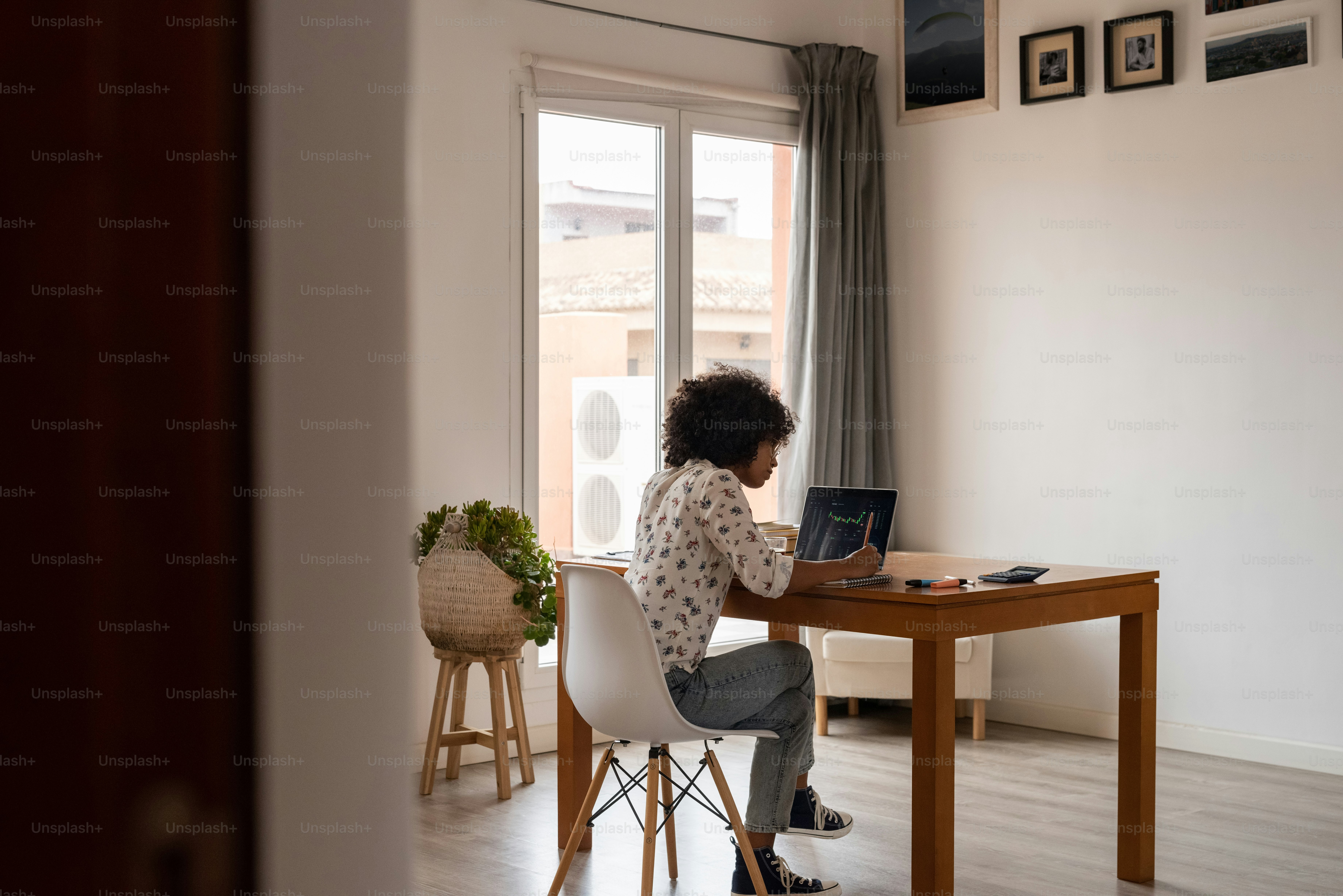 a woman sitting at a table using a laptop computer