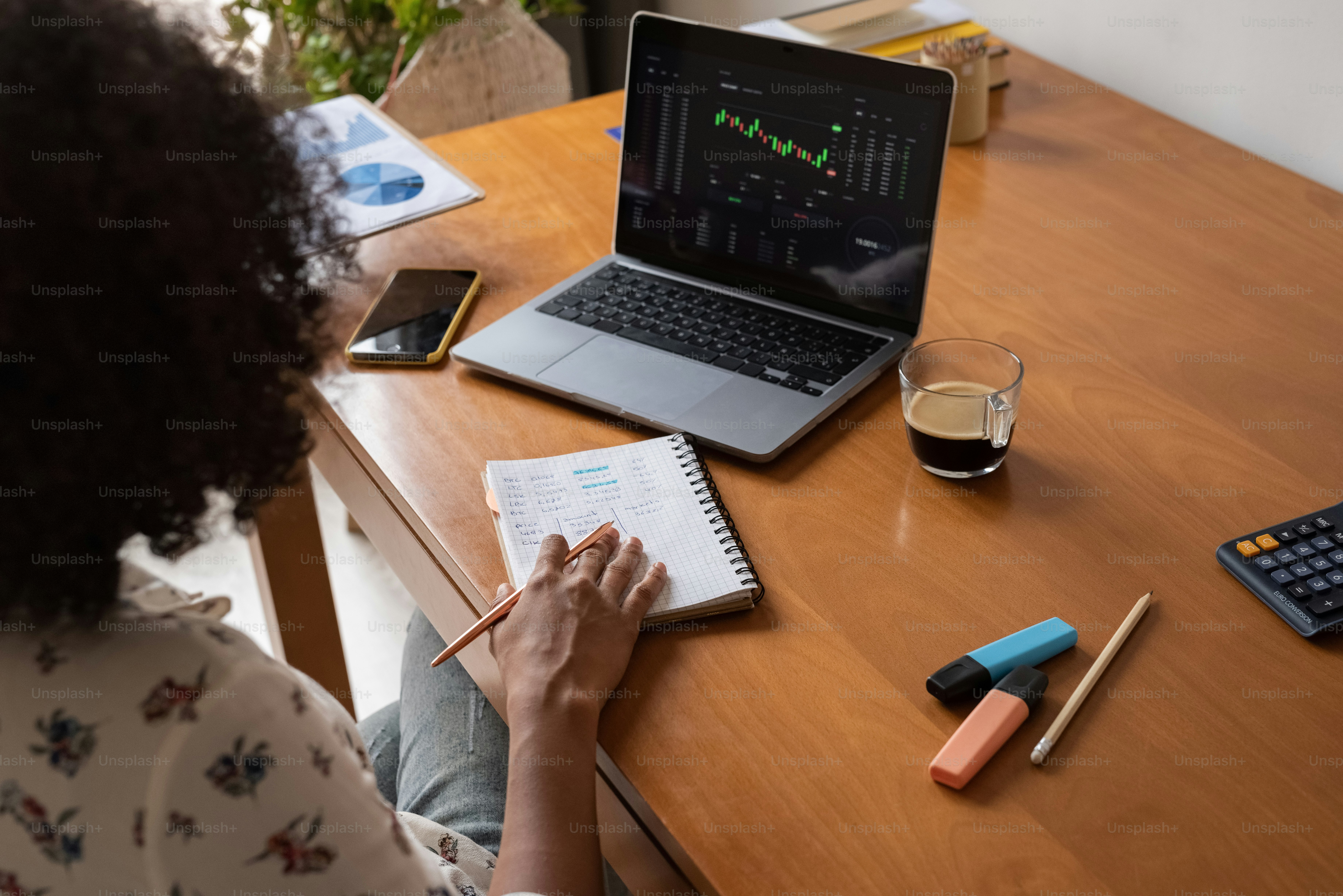 a woman sitting at a desk with a laptop and calculator