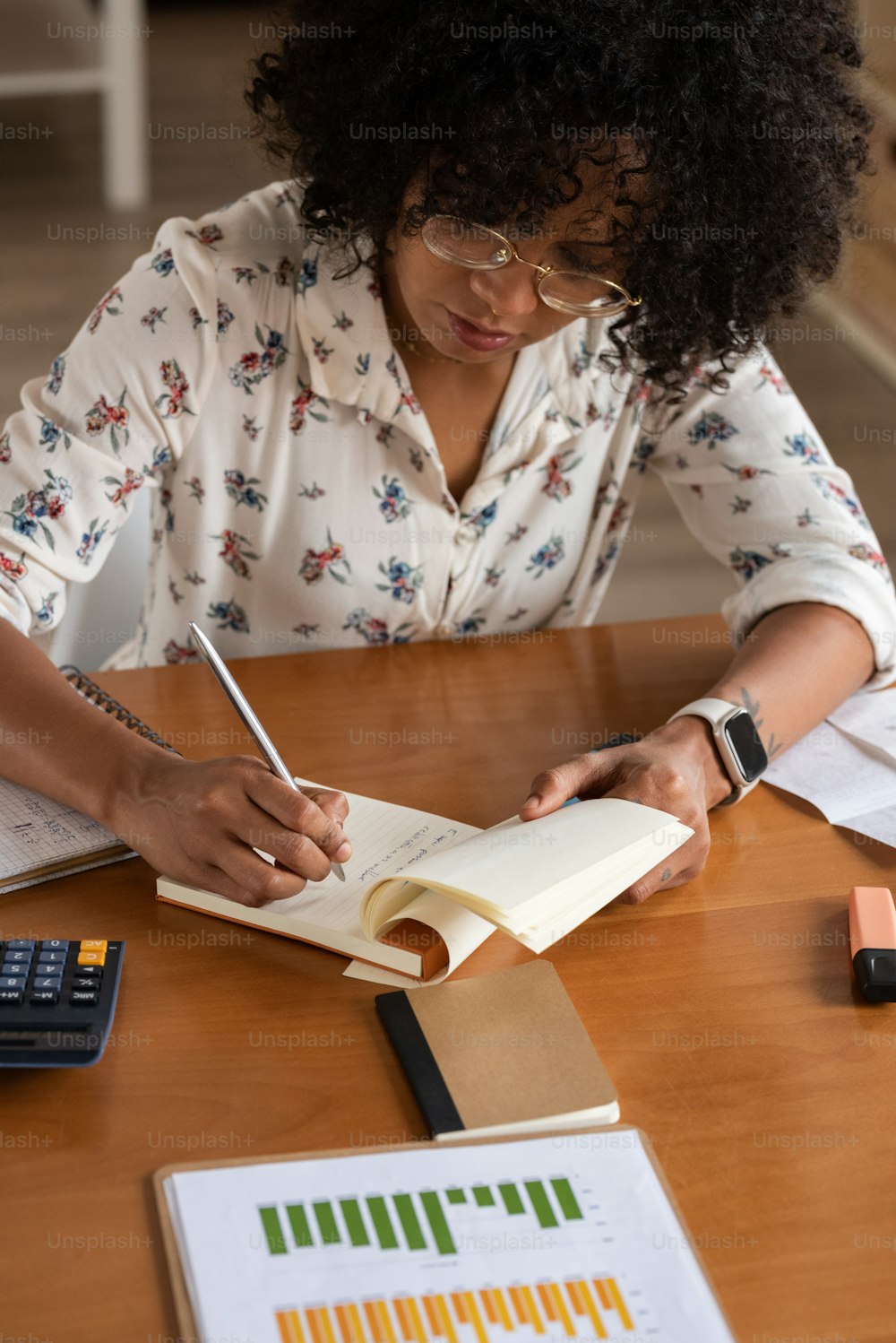 a woman sitting at a table with a book and calculator