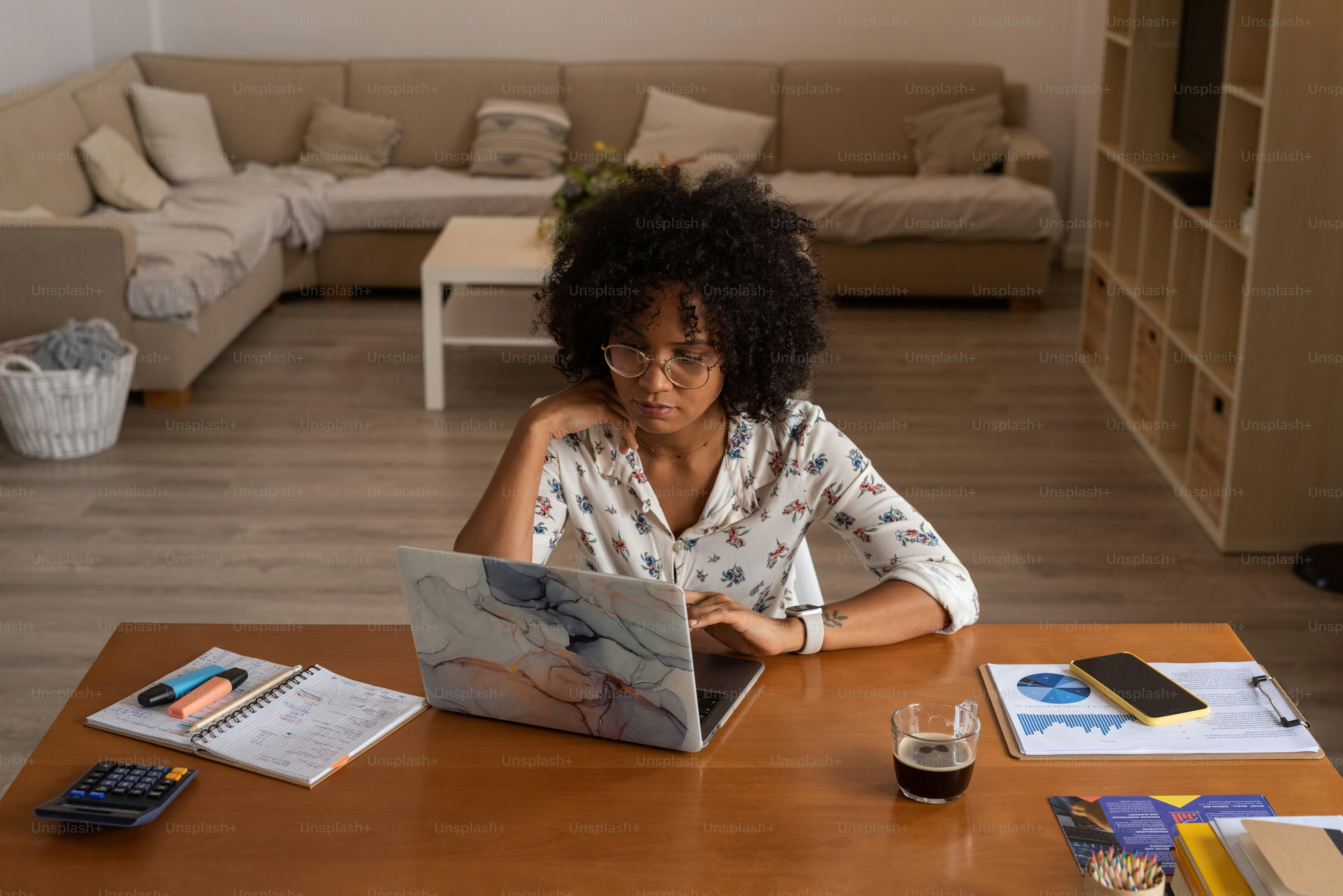 a woman sitting at a table using a laptop computer