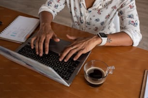 a woman sitting at a table using a laptop computer
