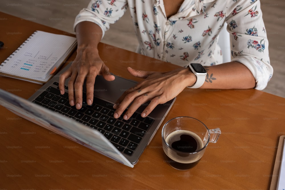 Una mujer sentada en una mesa usando una computadora portátil