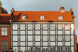 Un edificio alto con un tetto rosso e finestre