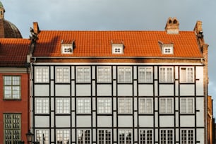 a tall building with a red roof and windows