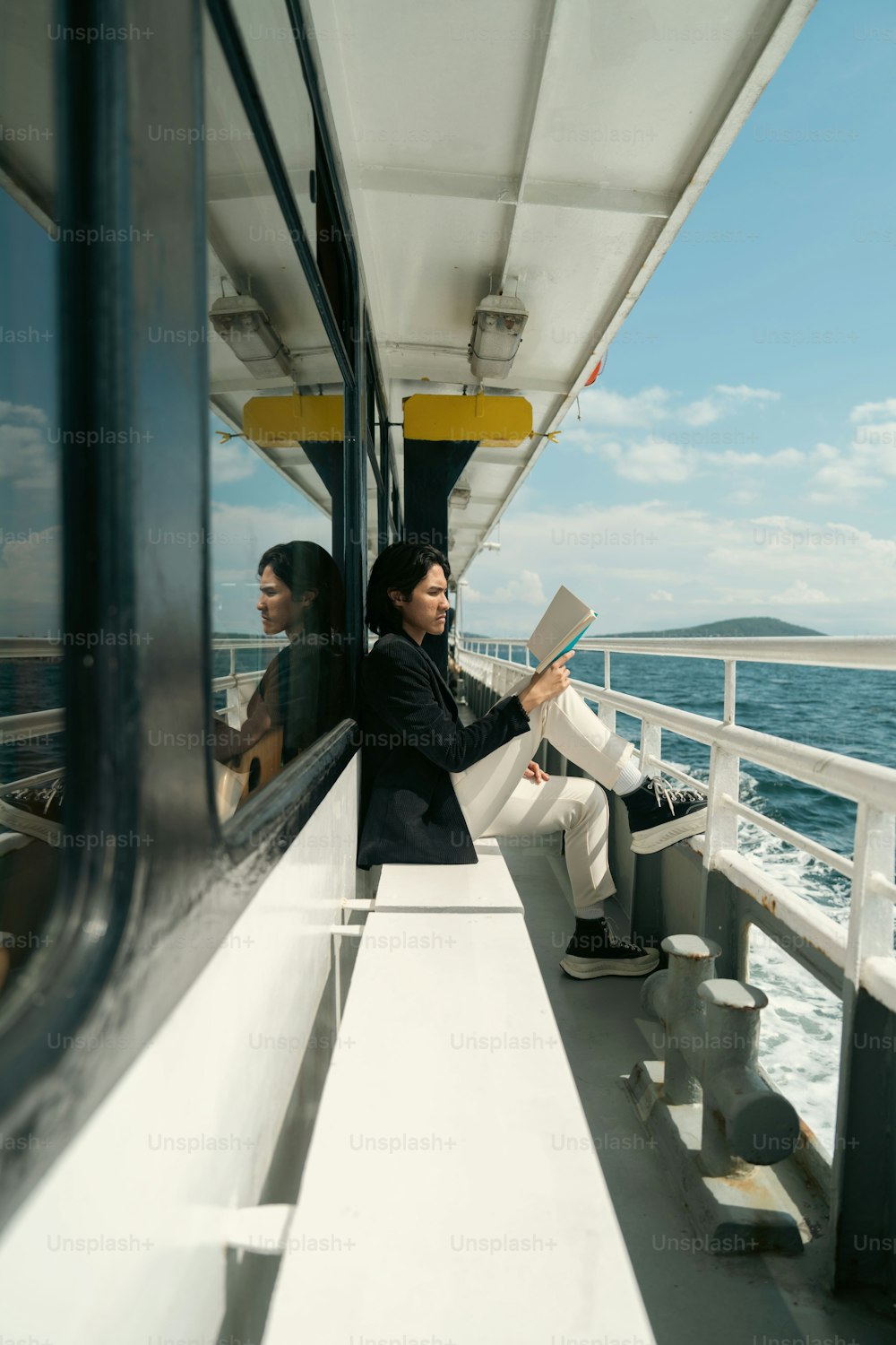 a woman sitting on a boat reading a book