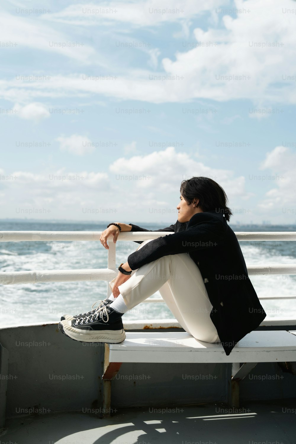 uma pessoa sentada em um banco perto do oceano