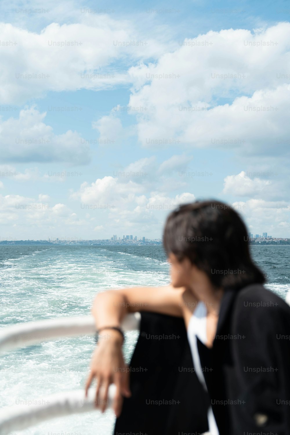 eine frau, die auf einem boot sitzt und auf den ozean schaut