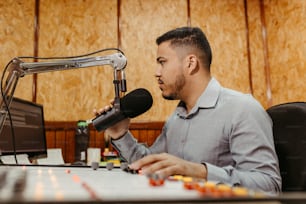 a man sitting at a desk in front of a microphone
