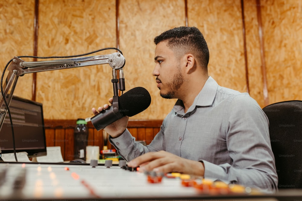 Un uomo seduto a una scrivania davanti a un microfono