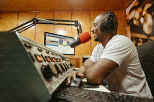 a man sitting in front of a computer with headphones on