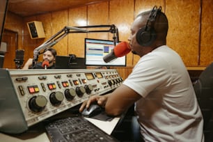 Un hombre sentado frente a una radio con auriculares puestos