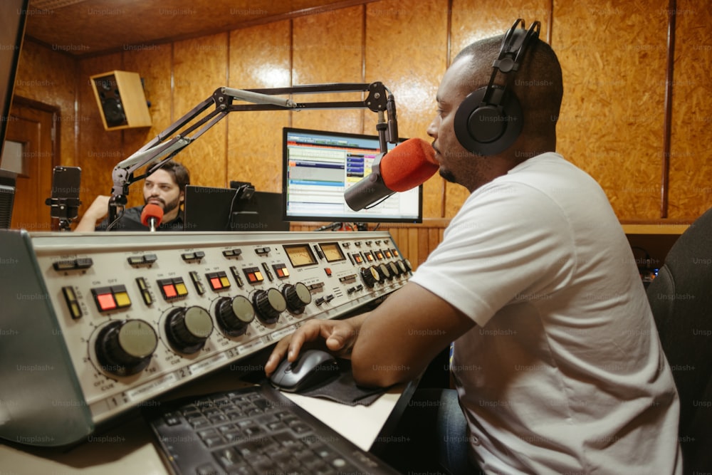 a man sitting in front of a radio with headphones on