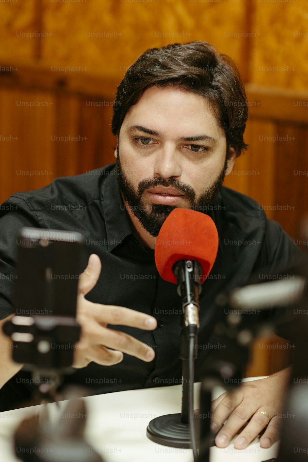 a man sitting at a table with a microphone in front of him