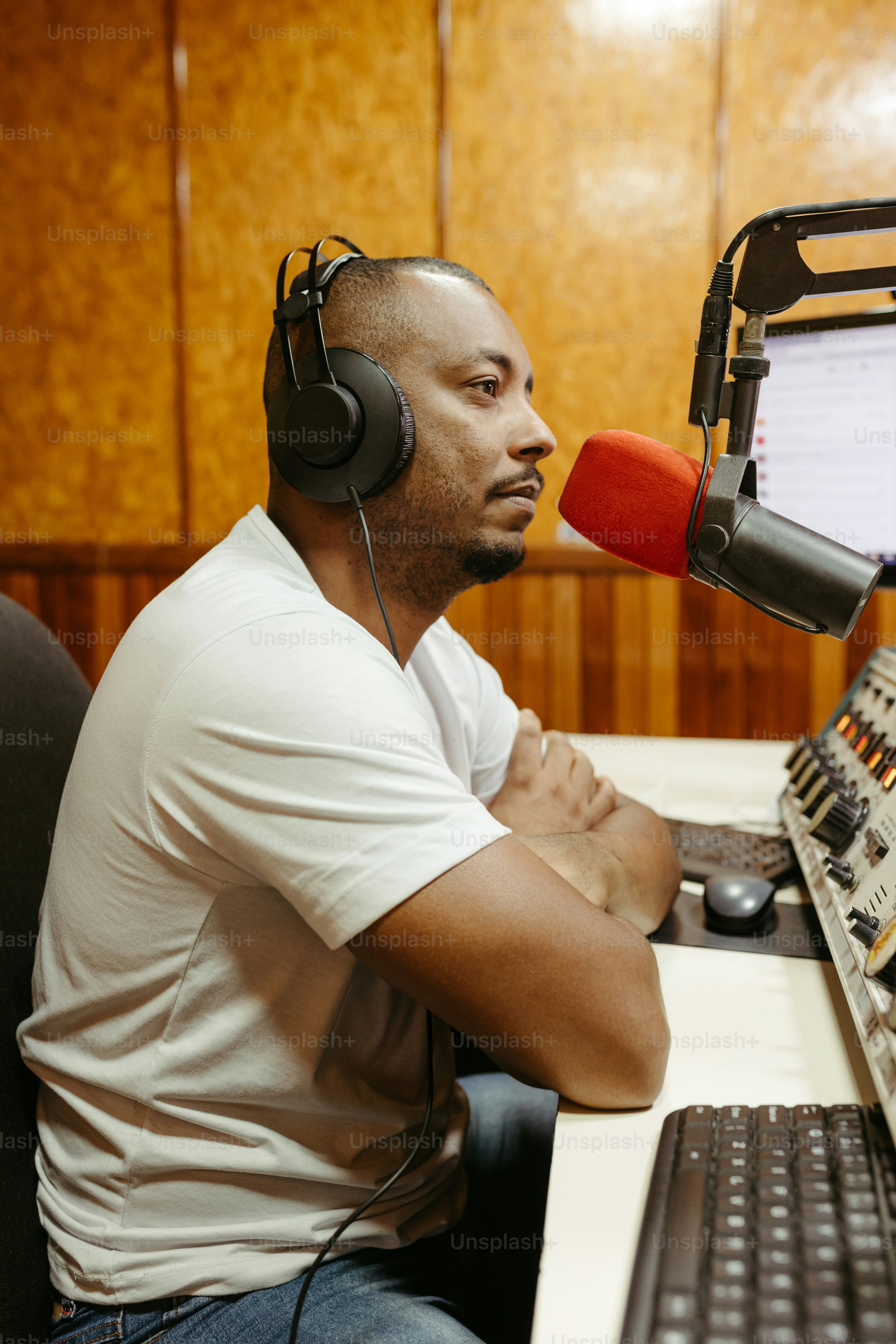 a man sitting in front of a computer with headphones on