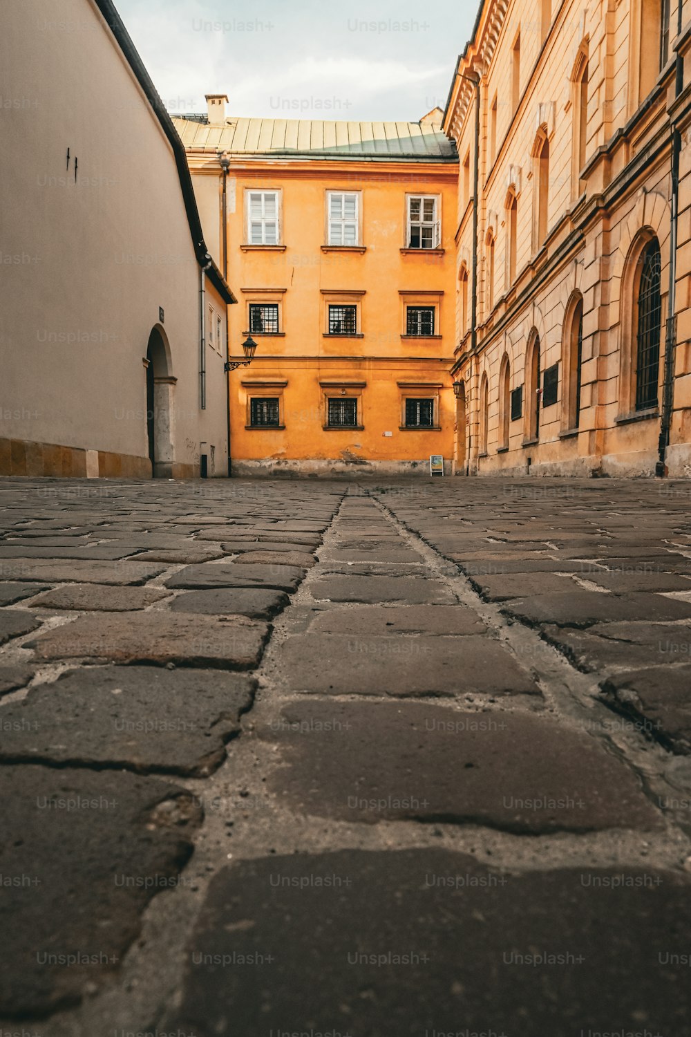 a cobblestone street with a building in the background