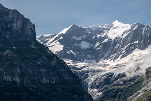 a mountain range covered in snow and clouds