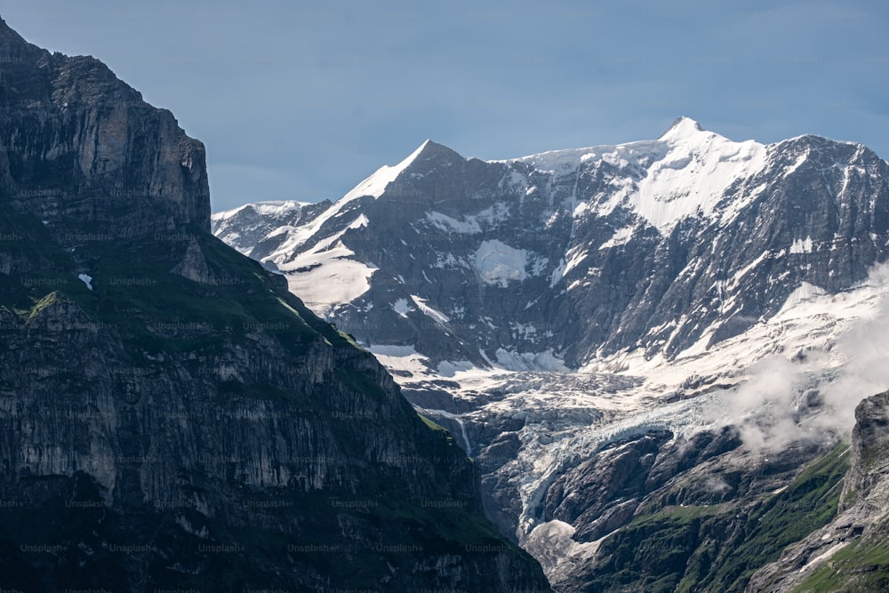 Une chaîne de montagnes couverte de neige et de nuages