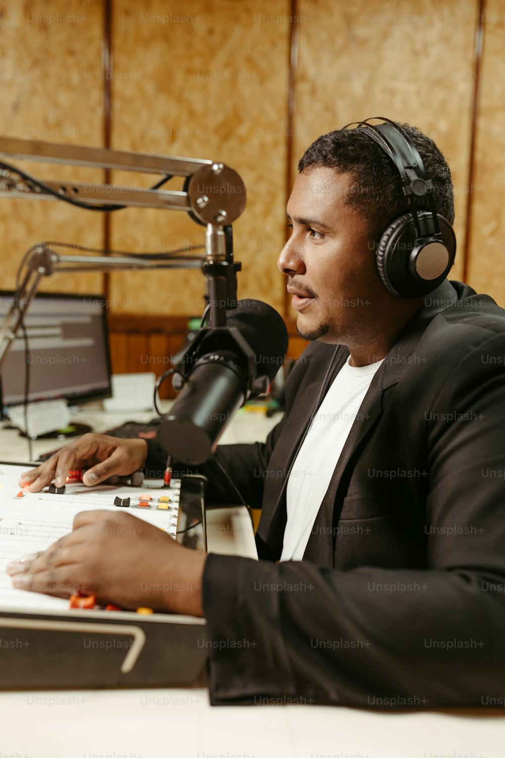 Un uomo che indossa le cuffie seduto davanti a un microfono