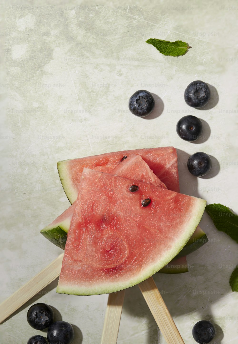 a watermelon and blueberries on a stick