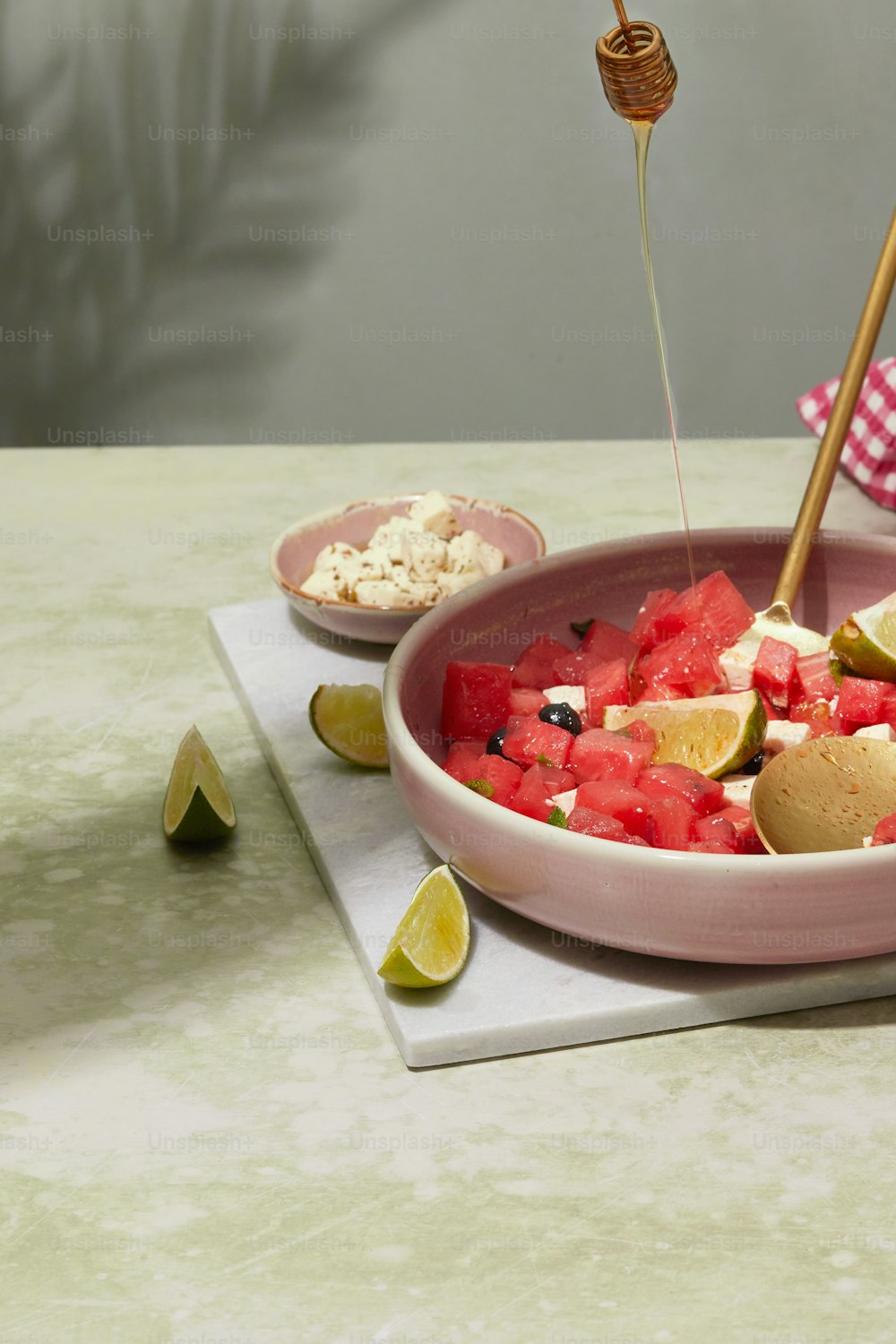 a bowl of watermelon and limes on a table