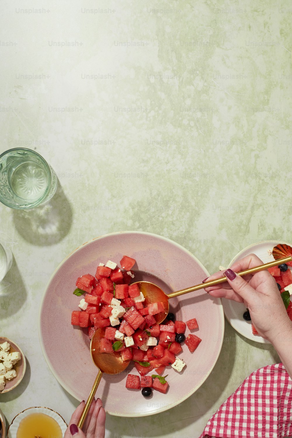una persona comiendo una ensalada en un plato con una cuchara