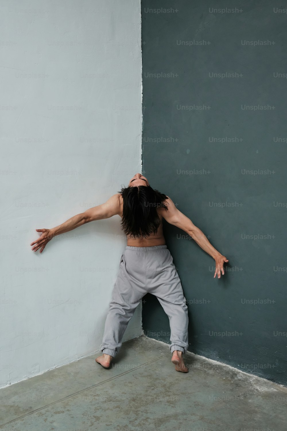a man leaning against a wall with his arms stretched out