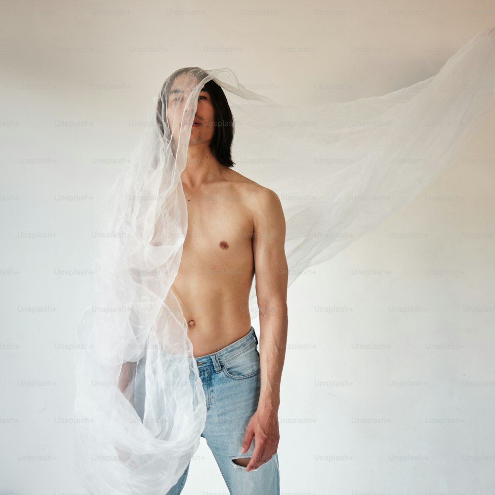 a shirtless man with a veil over his head