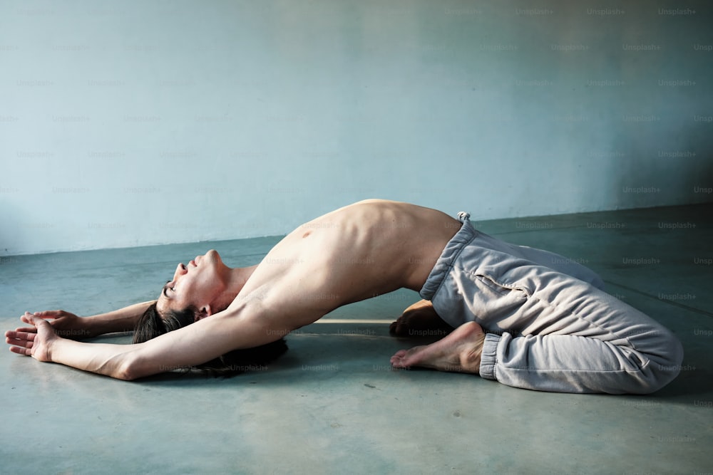 a shirtless man laying on the floor in a room