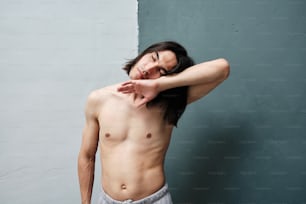 a shirtless man with his hand on his head