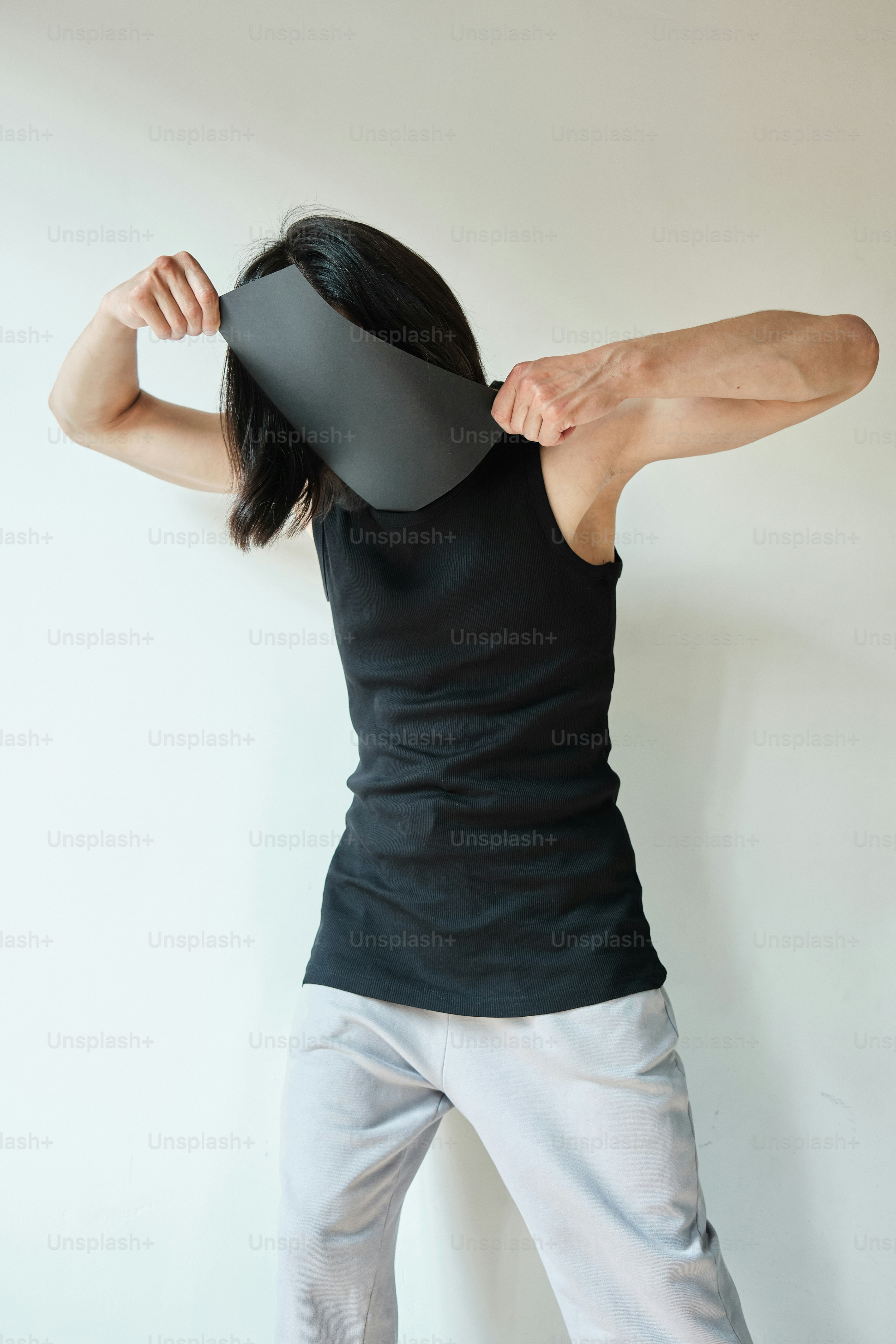 Una mujer sosteniendo un objeto negro sobre su cabeza