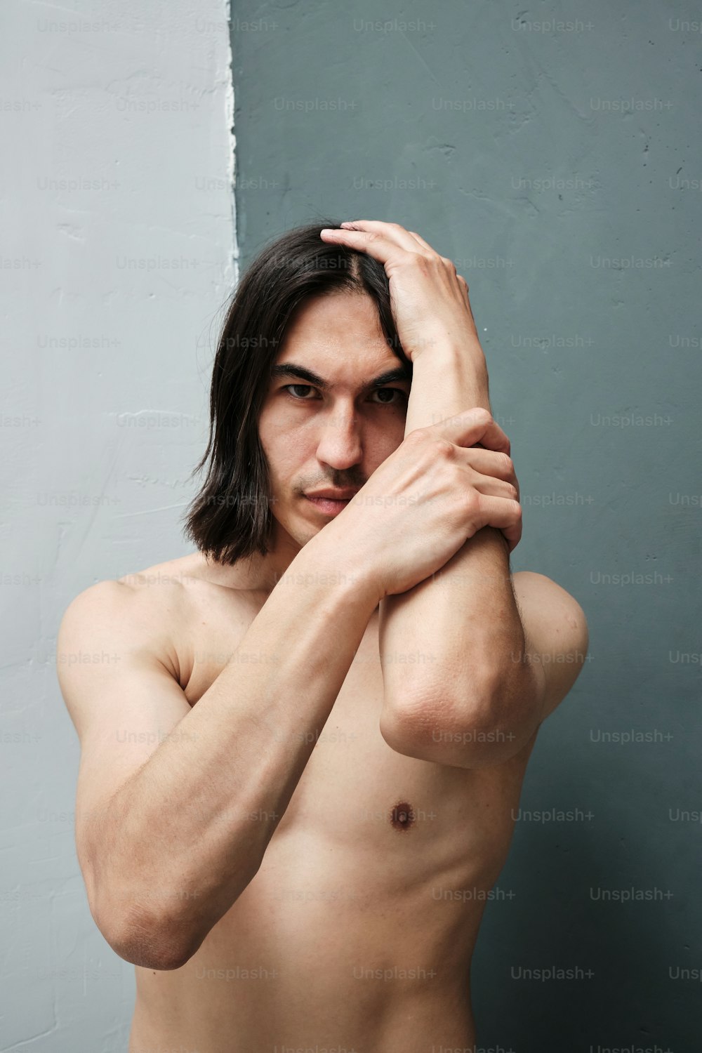 a man with long hair and no shirt posing for a picture