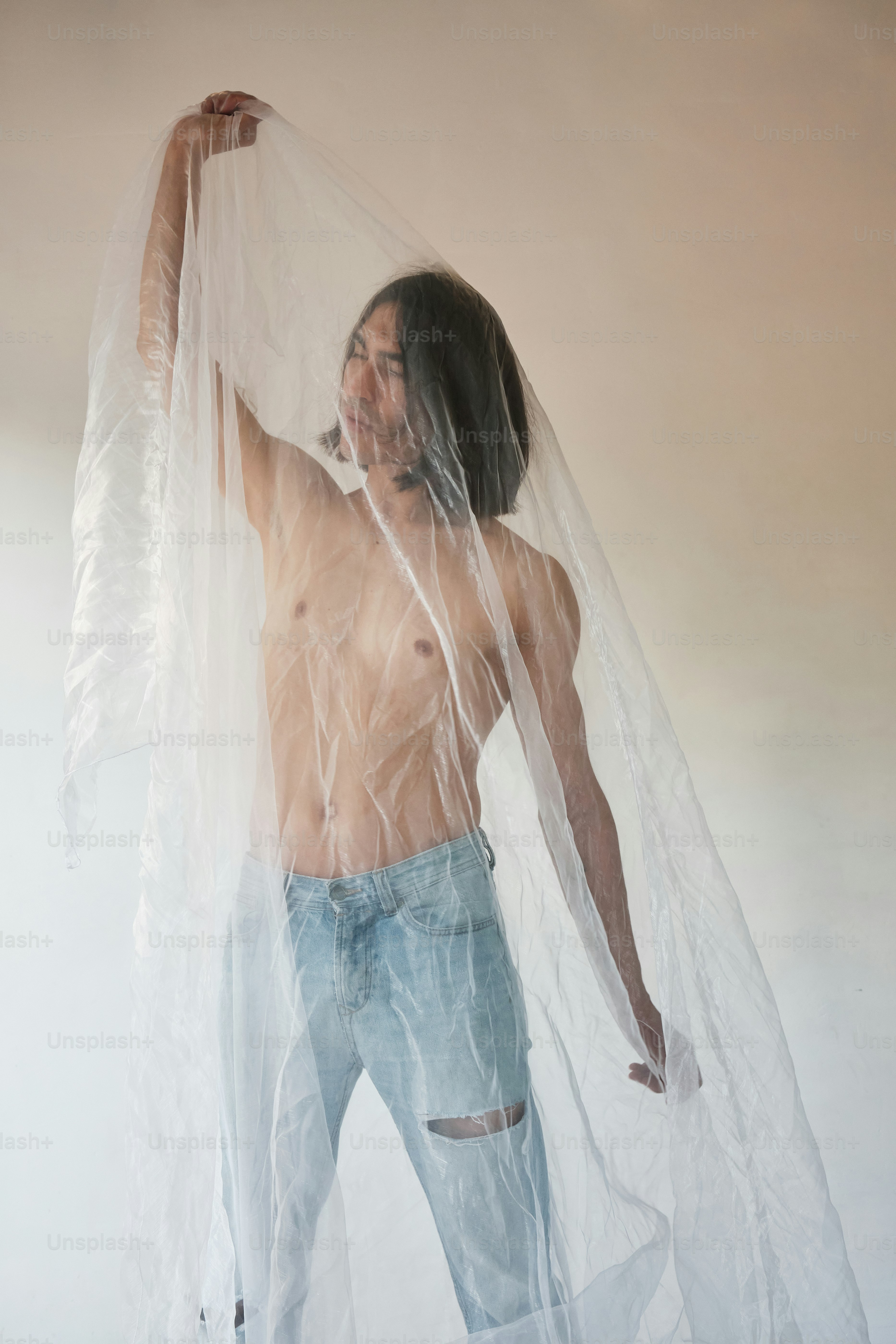 a shirtless man with a plastic covering his face
