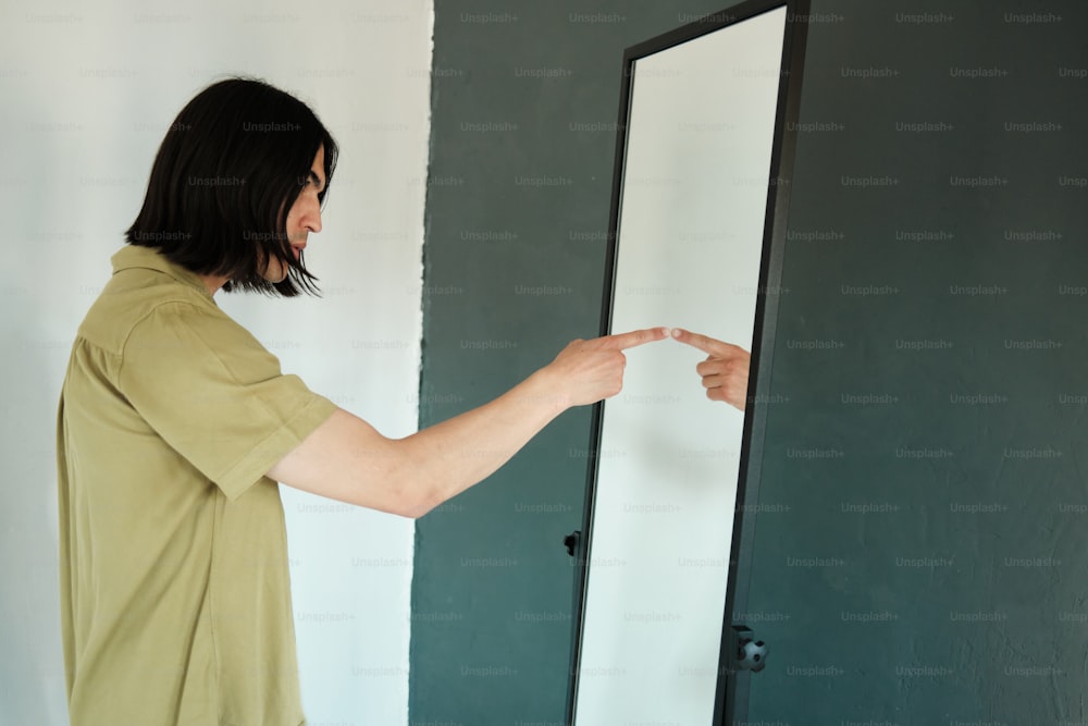 Ein Mann zeigt auf einen Spiegel in einem Raum