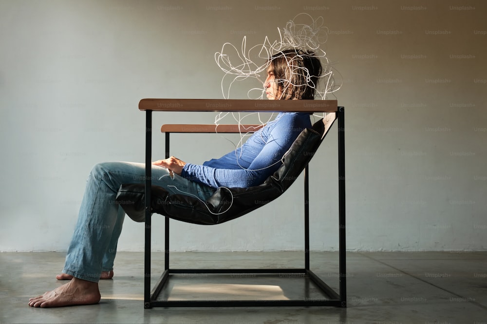 a woman sitting in a chair with a hair dryer on her head