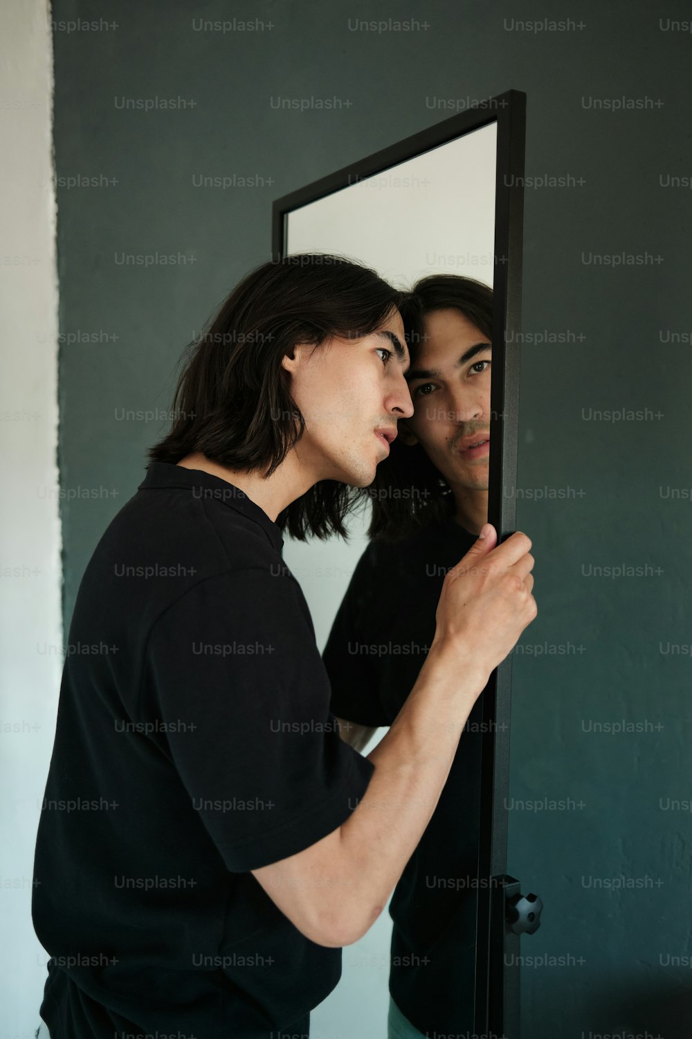 a man and a woman are looking at their reflection in a mirror