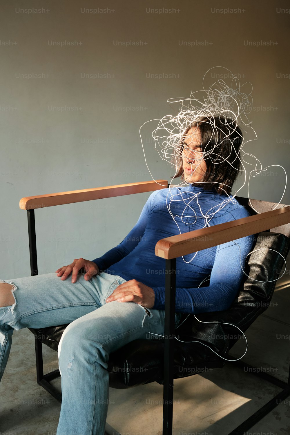 una donna seduta su una sedia con fili in testa