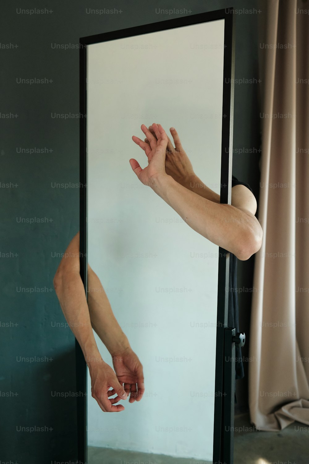 a person reaching for their hand in front of a mirror