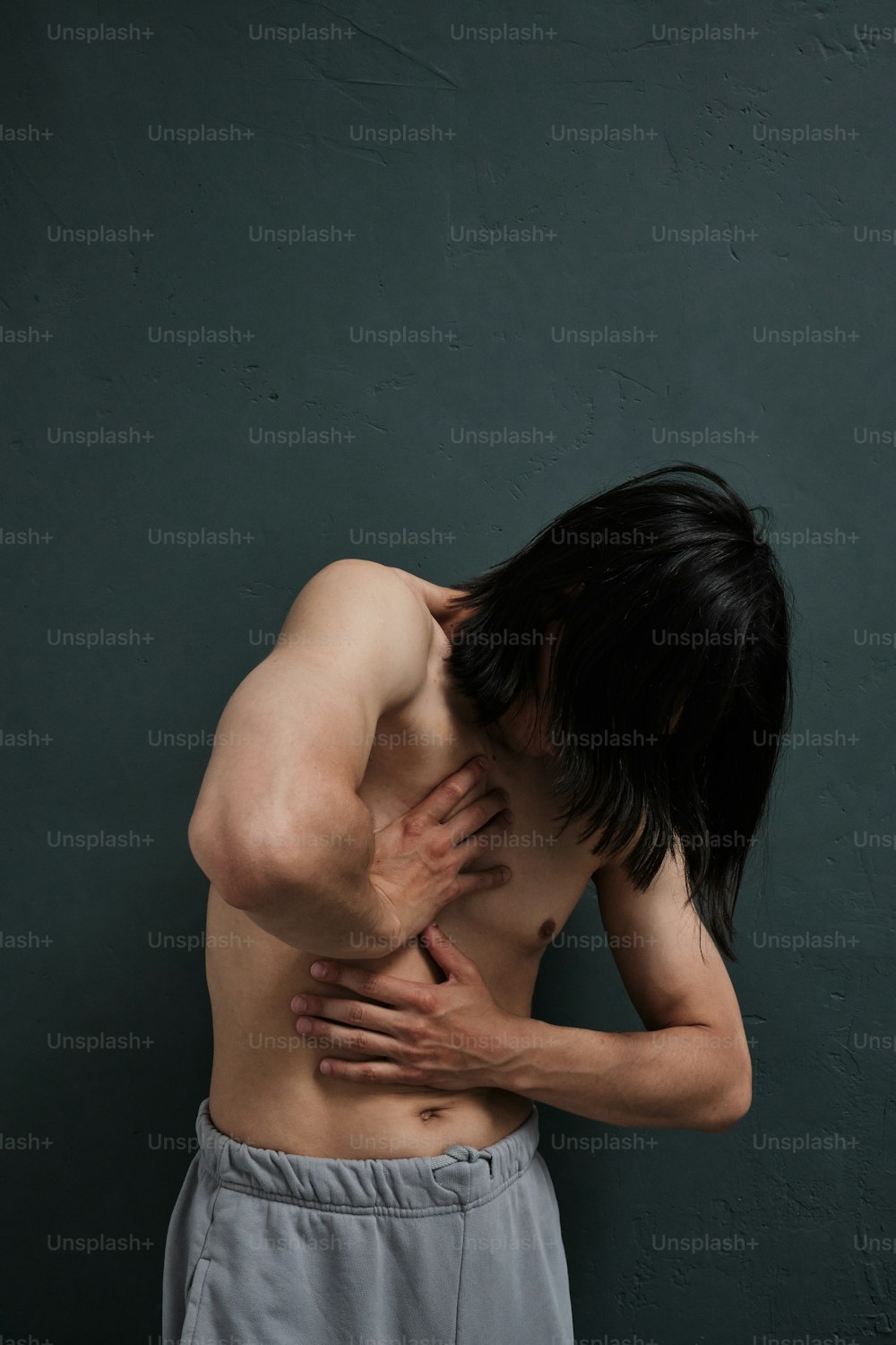 un uomo a torso nudo con le mani sul petto