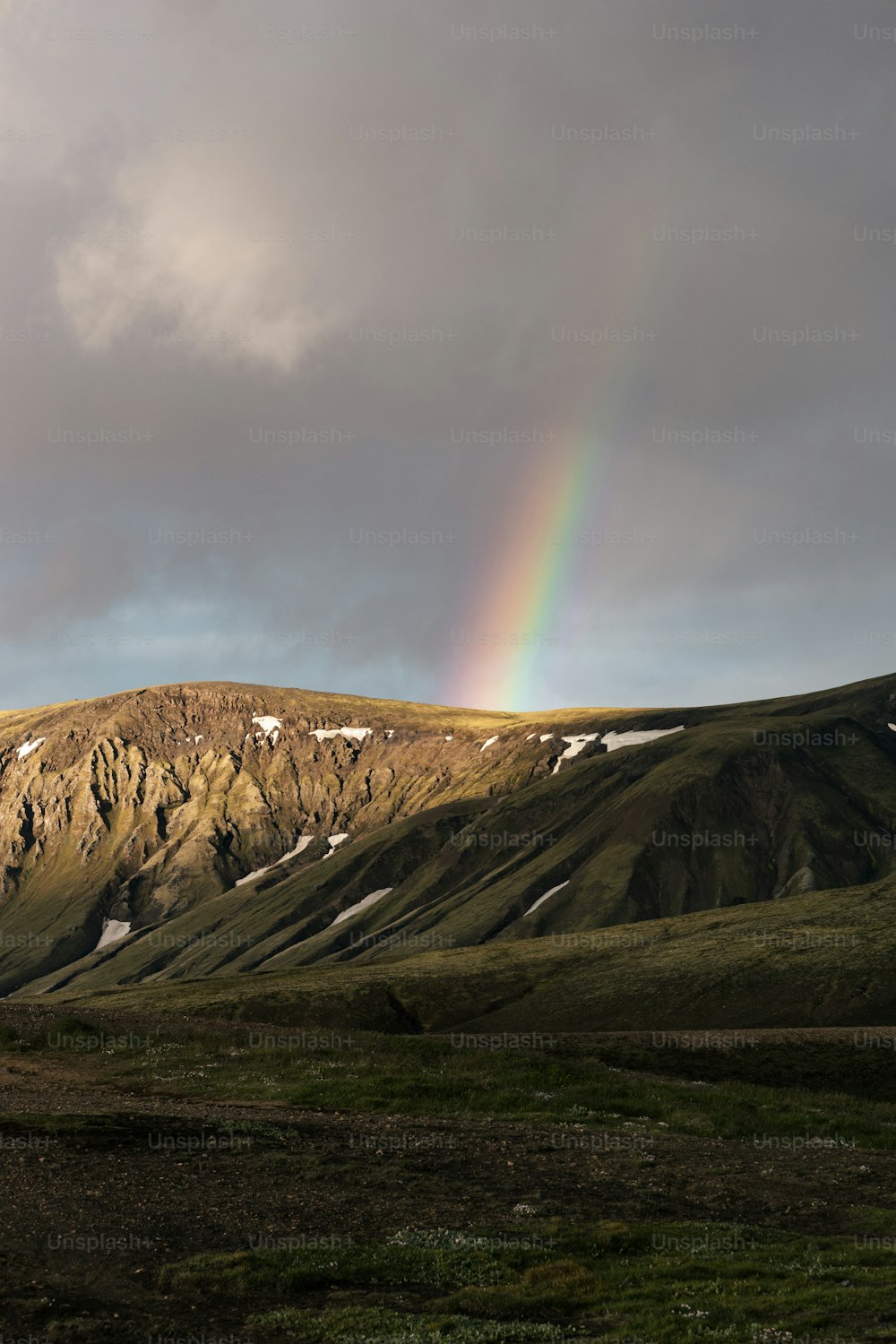 a rainbow in the sky over a mountain range