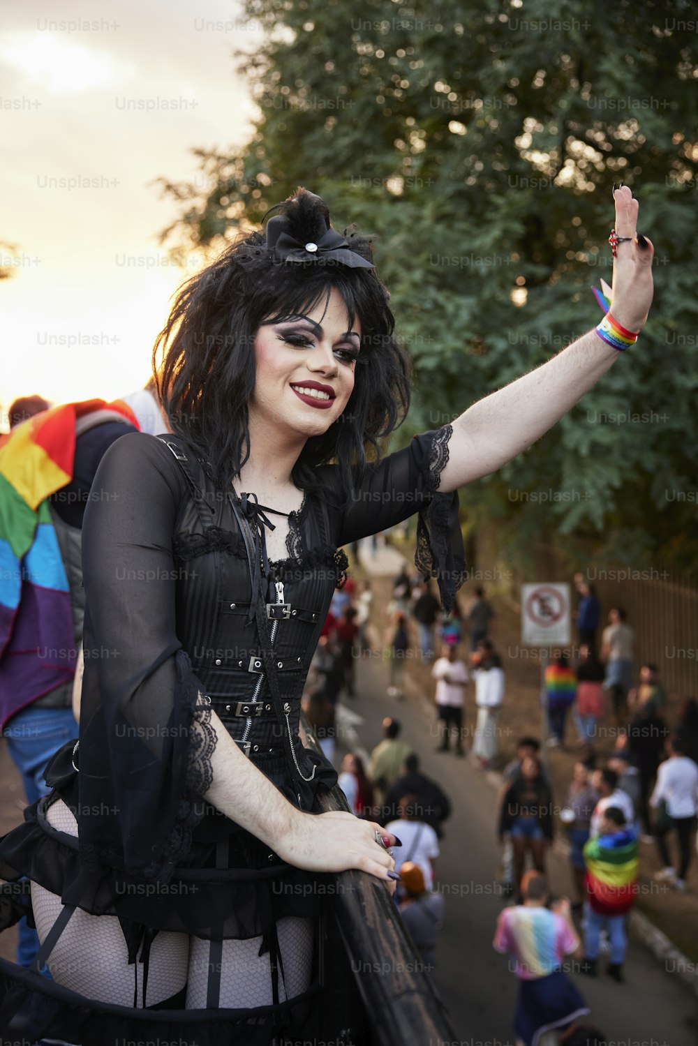 a woman in a black outfit and a rainbow flag