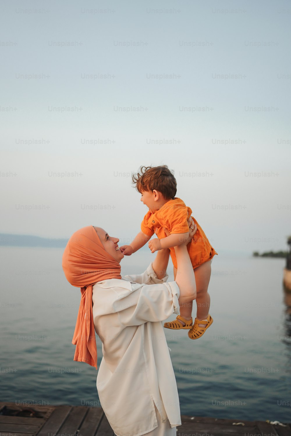 a woman holding a child on a dock