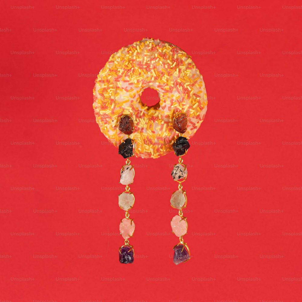 a donut with beads hanging from it on a red background