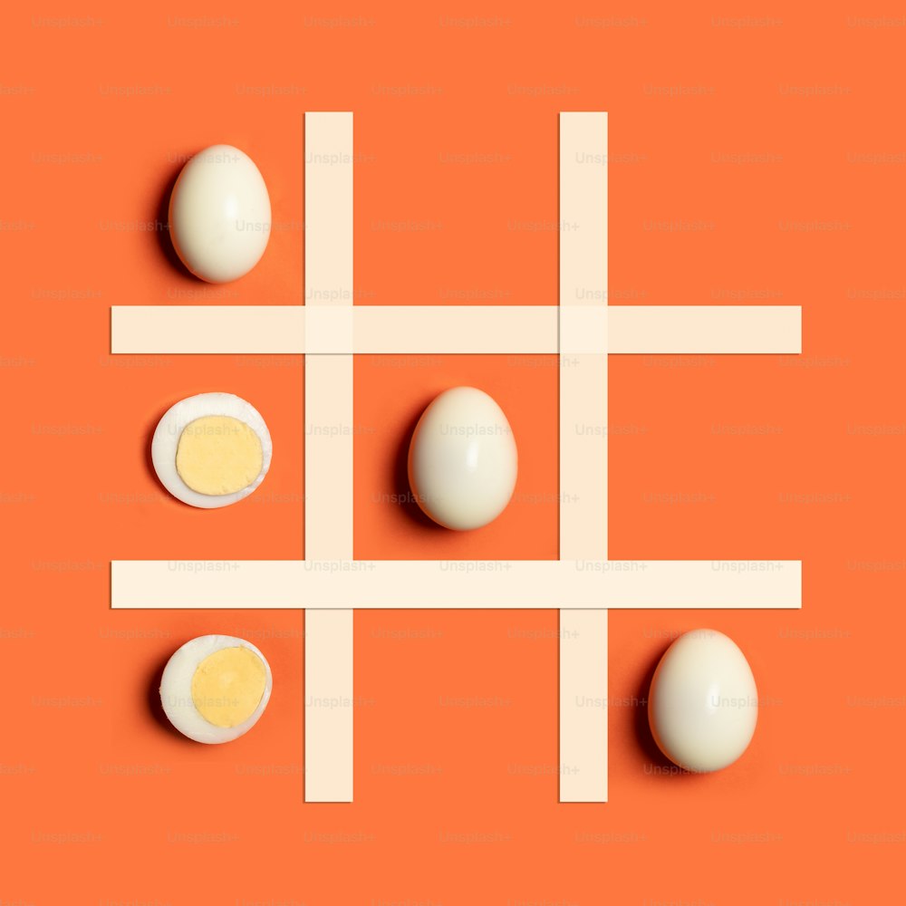 un gioco tic - tac - punta con uova su sfondo arancione