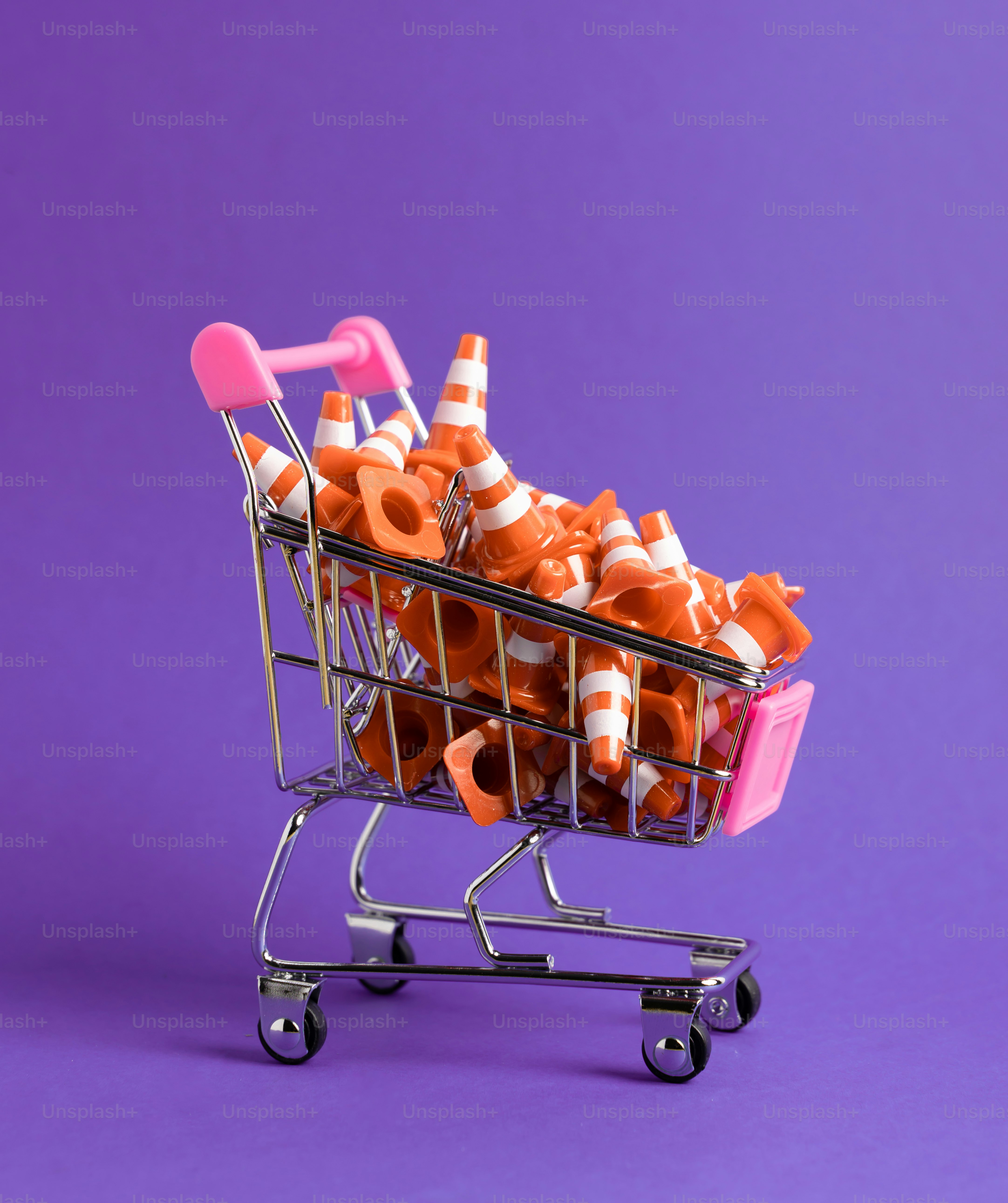 Un carrito de compras lleno de conos de tráfico naranjas