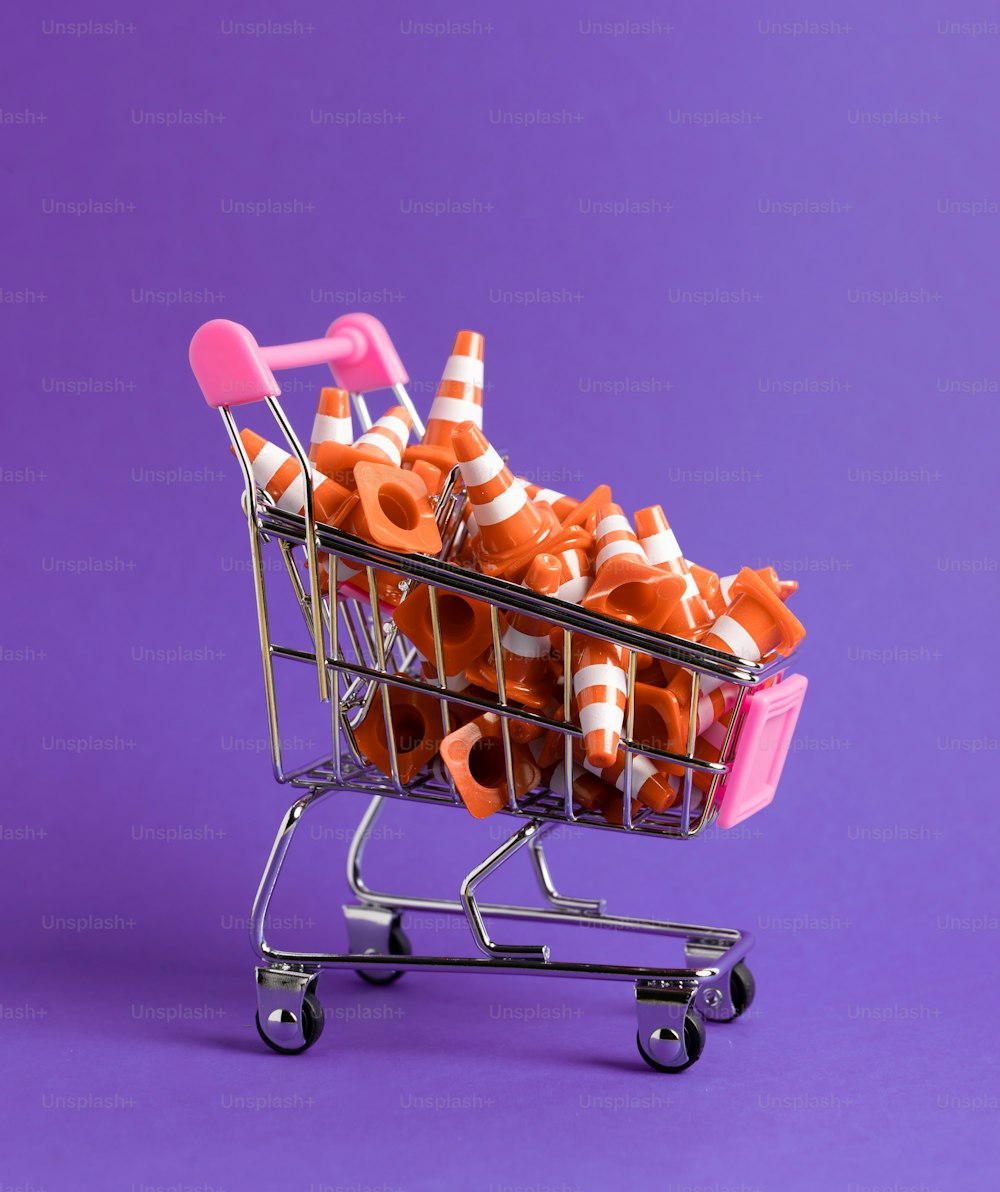 a shopping cart filled with orange traffic cones
